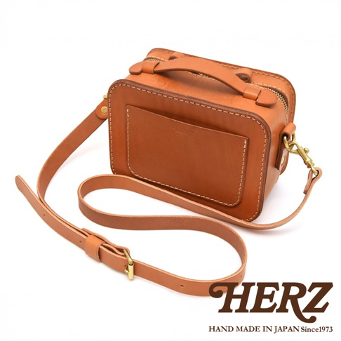 日本HERZ手工製作的棕褐色皮革兩用迷你小方包，帶有可拆卸肩帶和品牌標誌。