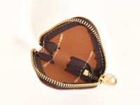 職人手作皮革三角飯糰造型零錢包，採用棕色皮革材質，搭配金色拉鍊，縫線清晰，內部有深色拉鍊與縫製細節。