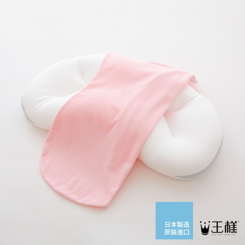 王樣の雲上枕，一個白色、帶有粉紅色布料覆蓋的嬰兒定型枕，布料材質柔軟，枕頭設計成環狀，有助於支撐嬰兒的頭部。