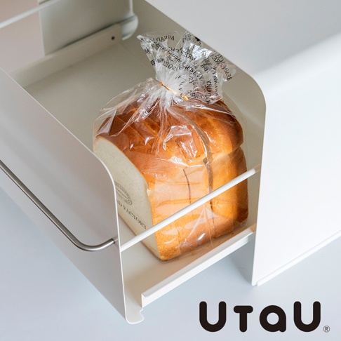 UtaU 抽屜式多功能萬用收納整理櫃內放著一條包裝好的吐司，櫃子為白色金屬材質，吐司裝在透明塑膠袋內，塑膠袋上有黑色印刷文字，吐司表面呈現誘人的金黃色。