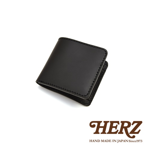 職人手作黑色皮革經典雙折短夾，皮革表面光滑，邊緣車縫線明顯。