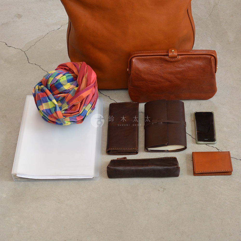 一組日本HERZ品牌皮革包具、圍巾、筆記本和手機，其中包含部分日文品牌文字。