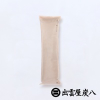 淺米色長條形木炭包，外層為無紡布材質，中央有細線縫合，頂部有封口，印有品牌標誌與中文「出雲屋炭八」，適合用於櫥櫃。