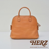 經典貝殼造型手提包，採用棕褐色皮革製作，配有雙提把與側邊拉鍊，包身正面有品牌壓印標誌。