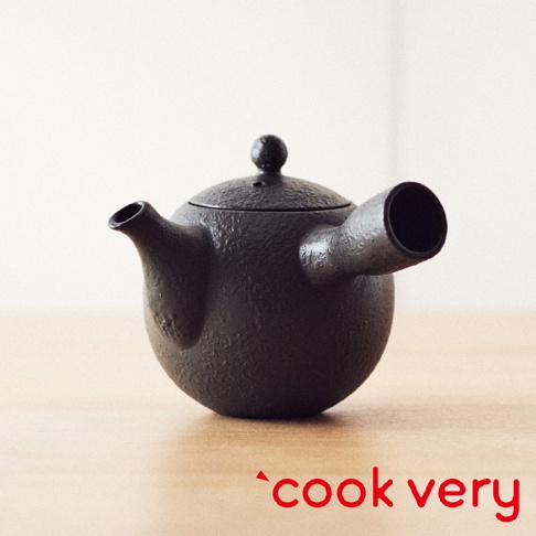 一個黑色的常滑燒咖啡急須茶壺，壺身圓潤，有兩個對稱的壺嘴，一個帶有壺蓋。