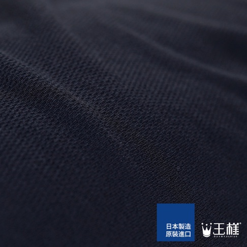 深藍色純色網狀織物材質的枕套特寫，布料表面有細微紋理，角落有「日本製造 原裝進口」和「王樣 OSAMA SERIES」的標誌。