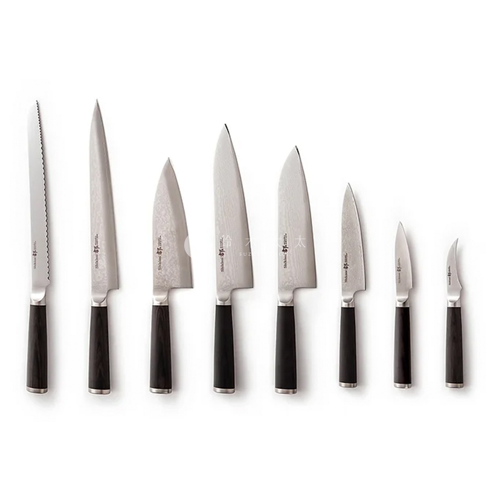 一把志津匠都系列水果刀，黑色手柄，精緻鋼刃，刀刃有細微紋理，另有七種不同尺寸的廚房刀具，從左至右逐漸變小，最右邊是一把彎月形的小刀。