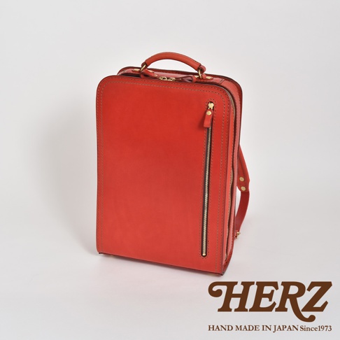 紅色皮革商務電腦後背包，設有頂部提把、拉鍊開合和側邊肩帶。