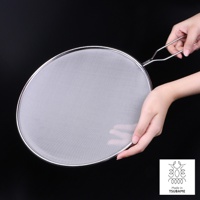 銀色金屬透視防噴濾網，網狀細密，邊緣光滑，配有金屬手柄，由雙手持握，背景為黑色。