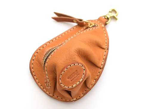 職人手作皮革餃子造型零錢包，採用棕褐色皮革，有拉鍊開合，並配有金色掛鉤和皮革拉帶，整體呈現餃子形狀。