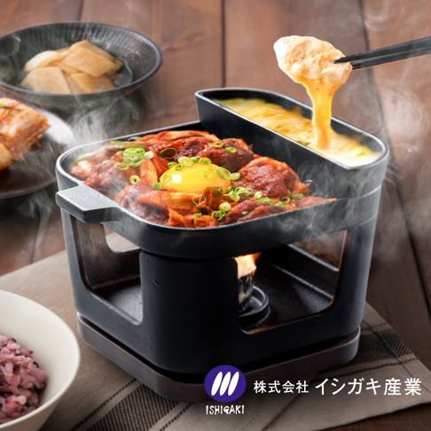 桌上型鑄鐵烤盤鍋爐組，黑色鑄鐵鍋身，內有燉煮的肉類與泡菜，上方還有融化的起司，搭配木質底座與加熱爐，整體冒著熱氣，呈現誘人料理畫面。