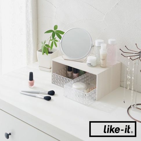 淺木紋雙層整理架，附兩個透明收納盒，架上擺放化妝鏡、保養品、指甲油，架內收納指甲油和化妝棉，一旁有化妝刷具。