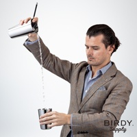 一名身穿格紋西裝的調酒師，手持不鏽鋼調酒杯，將液體倒入另一個不鏽鋼杯中，杯內可見長柄濾酒隔冰匙。