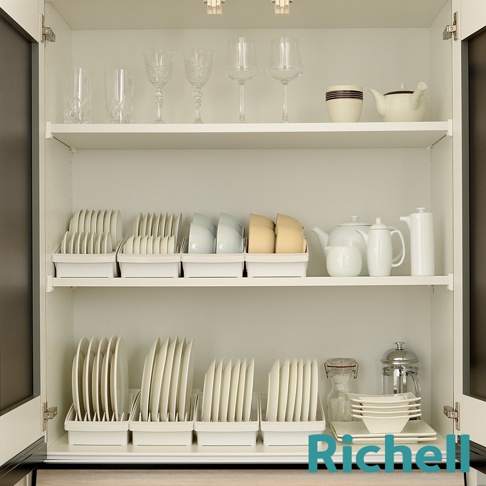 櫥櫃內擺放著各式餐具，頂層有玻璃杯、酒杯、茶壺、杯子；中層有餐盤收納架，架上擺放著大小盤子、碗；底層有更多的盤子收納架，架上擺放著盤子，還有茶壺、咖啡壺、碗疊等。