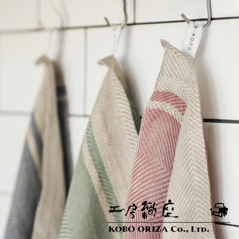 純亞麻斜紋織紋廚房拭巾，以紅、綠、藍灰條紋搭配米白色，掛在掛勾上。