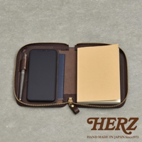 職人手作皮革Organ記事本收納包，內含手機、護照及筆記本，咖啡色拉鍊設計，展現精緻手藝。