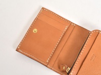 棕色皮革直式卡片收納雙折短夾，內含多個卡片夾層、一個按扣，以及一個拉鍊零錢袋，整體以米白色縫線手工縫製。