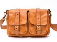 棕褐色皮革雙口袋肩背包，配有兩個翻蓋口袋，每個口袋上都有皮帶和金屬扣環，肩帶可調節，側邊有金屬鉤環。