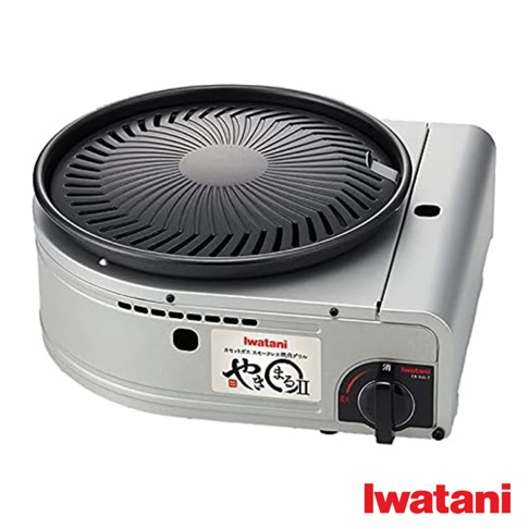 Iwatani CB-SLG-2 無煙燒烤爐，銀色金屬機身，配備黑色螺旋紋烤盤。烤盤中央有出油孔，機身側邊有黑色旋鈕和通風孔，並貼有 Iwatani 品牌標籤。
