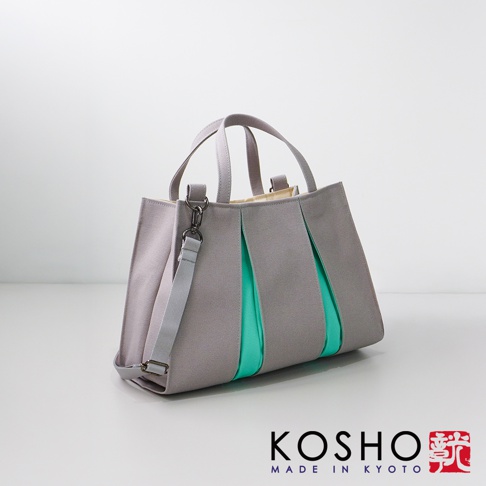 灰色棉帆布扇形托特包，搭配鮮綠色內襯，設有手提帶和可拆卸肩帶。