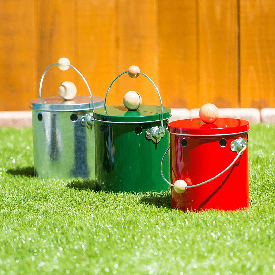 三個 OBAKETSU 手工製蚊香桶，分別為銀色、綠色和紅色，擺放在草地上，背景是木紋圍籬。