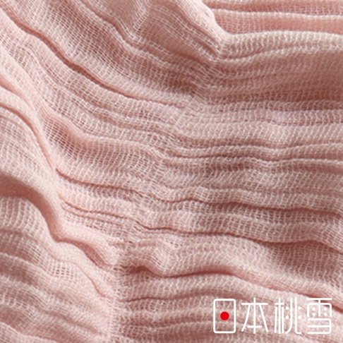 這是一張日本桃雪四季萬用抗UV純棉紗布圍巾的局部細節照，呈現粉紅色的純棉材質，表面擁有明顯的波浪狀抓皺紋理與細緻的紗布編織結構。