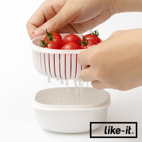 雙層白色塑膠保鮮盒，上層濾籃裝有紅色小番茄，水分正從濾籃滴入下層保鮮盒中。