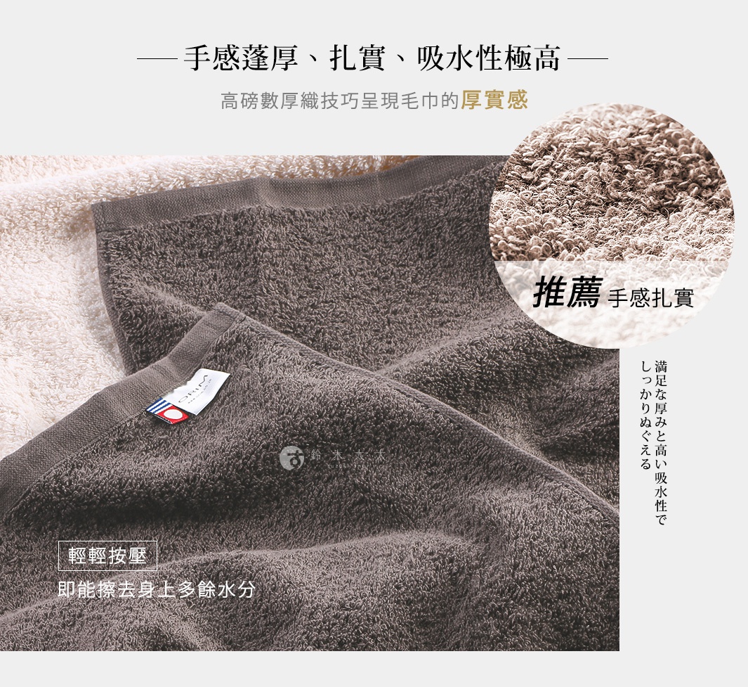 兩條深灰色今治沙龍浴巾，材質厚實，表面有細緻的絨毛紋理，其中一條浴巾上帶有品牌標籤。
