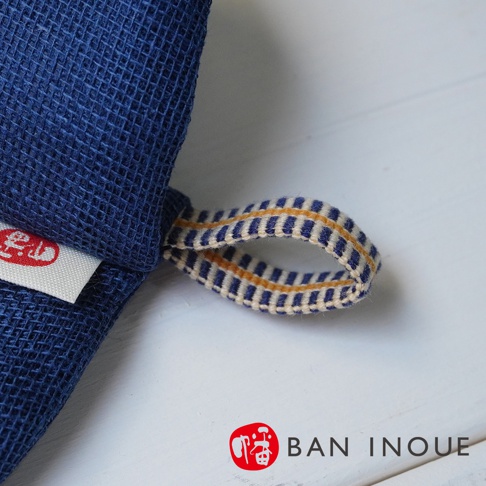 深藍色網紋布製成的防燙鍋套，配有藍白相間及黃色線條的掛繩，材質為布料。