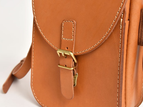 職人手作皮革翻蓋迷你單肩包 (CP-6)，採用天然棕色皮革製成，配有黃銅金屬搭扣和縫線細節，展現簡約復古風格。