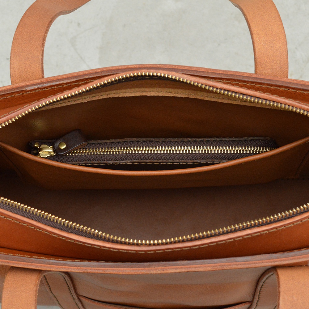 職人手作皮革Organ肩背拉鍊托特包，展示其內部結構，包含一個拉鍊內袋，採用光滑的棕色皮革和金色拉鍊。