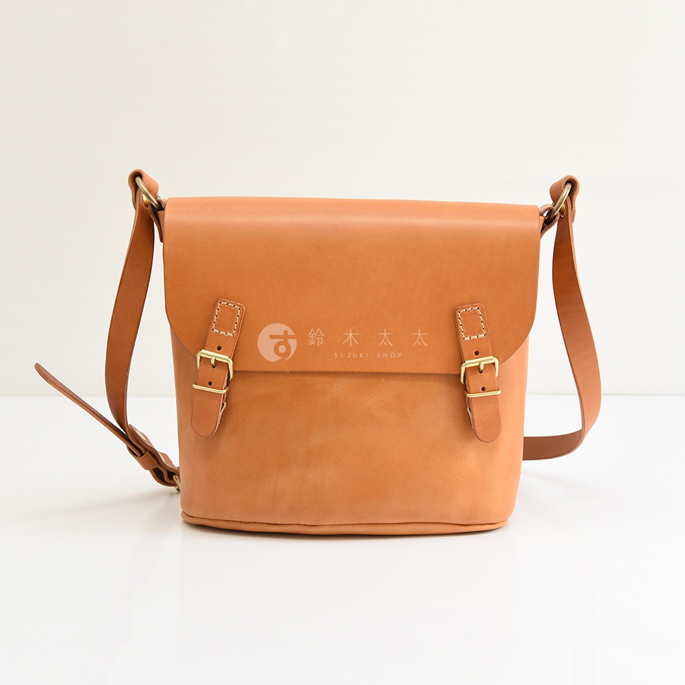 日本HERZ職人手作皮革雙扣旅行郵差包，淺棕色牛皮革製成，正面有雙插釦設計，簡約俐落。