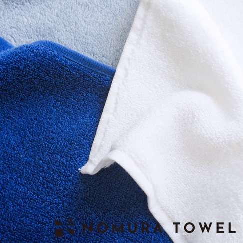 野村毛巾 3 色超無撚極吸水毛巾，其中一款為藍色，另一款為白色，上方疊加的為淺藍色毛巾，右下角有品牌 logo。