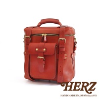 職人手作皮革大型三用旅行後背包，採用紅色皮革製成，設有頂部提把、拉鍊主袋、前方翻蓋口袋，並配有可調節的皮革肩帶和金屬扣環。