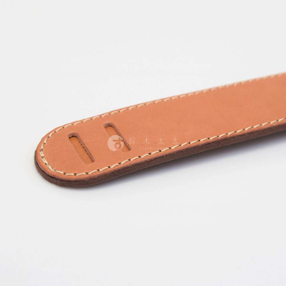 職人手作皮革Big肩墊，採用天然皮革製成，呈現溫潤的棕褐色。肩墊邊緣以細密的縫線處理，並設有兩個長形開口，方便調整。