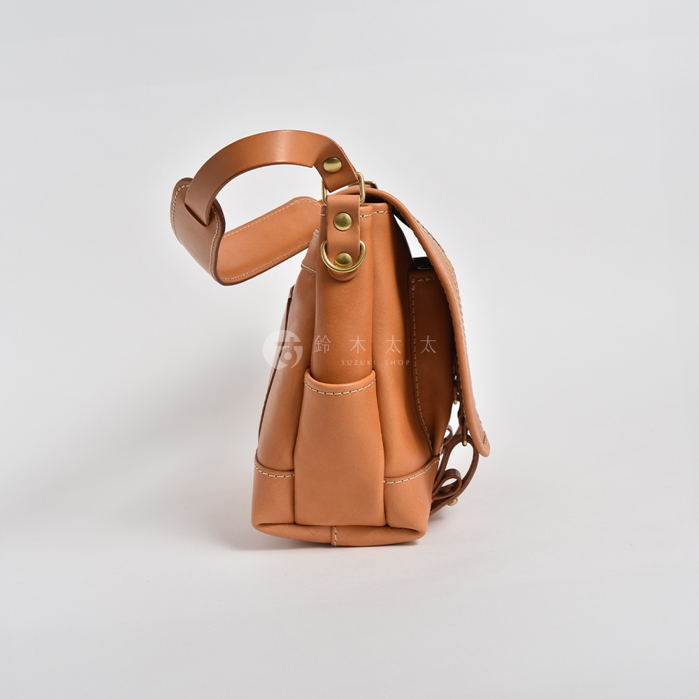 職人手作皮革復古郵差包，淺棕色，具備一個可調節的提把和外側口袋，以精緻縫線裝飾，搭配金屬釦件。