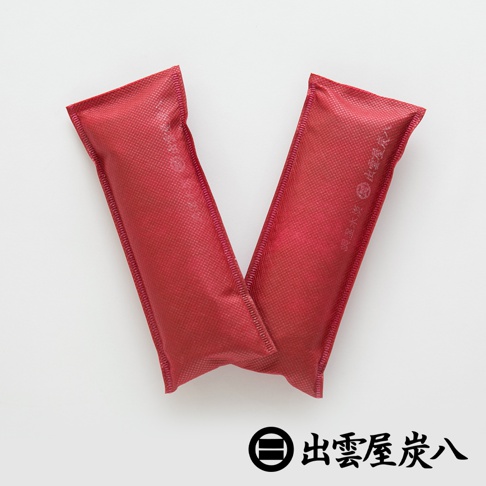 兩件紅色網紋布料製成的長條形調濕包，置於白色背景上，其中一件的布料上印有日文文字。