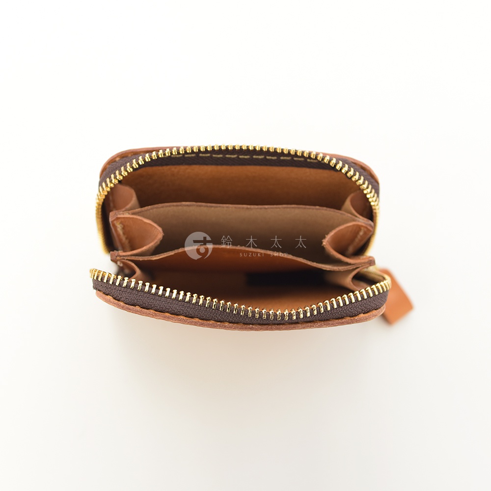 棕色皮革製成的圓形拉鍊錢包，內部有兩個隔層，拉鍊為金色，皮革拉片為棕色。