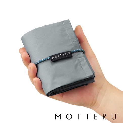 手持灰色摺疊式保冷袋，袋身以尼龍材質製成，束口處繫有藍黃色編織繩，袋中央有黑色品牌標籤。