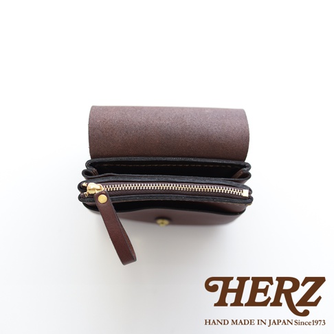 職人手作皮革旅行用雙層錢包，深棕色，以簡潔的設計展示其皮革紋理與精緻車縫，搭配金色拉鍊與皮革拉環。