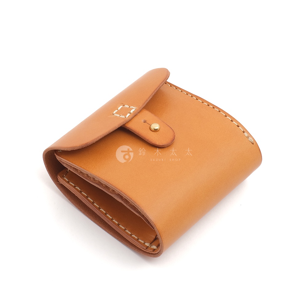 職人手作皮革原子釦型二折式短夾，採用天然皮革材質，呈現溫潤的棕褐色調。短夾設計簡潔，以金屬原子釦固定，車縫線清晰，展現細膩的工藝。