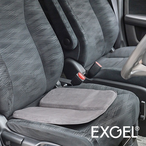 灰色折疊坐墊，採用絨面材質，置於汽車座椅上，坐墊表面有細小的透氣孔。