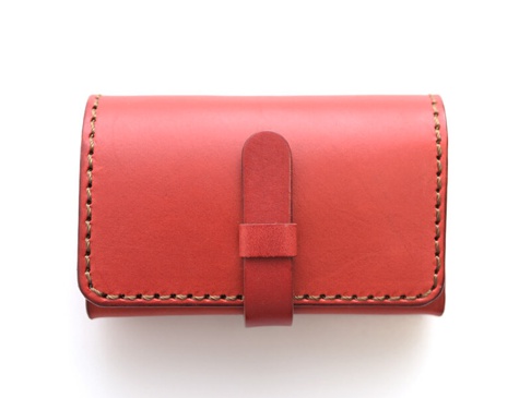 紅色皮革名片夾，壓扣式設計，邊緣以咖啡色縫線手工縫製。