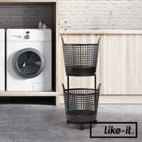 黑色的兩層式圓形洗衣提籃，由塑膠網格製成，帶有提把和輪子，放置於洗衣機旁。