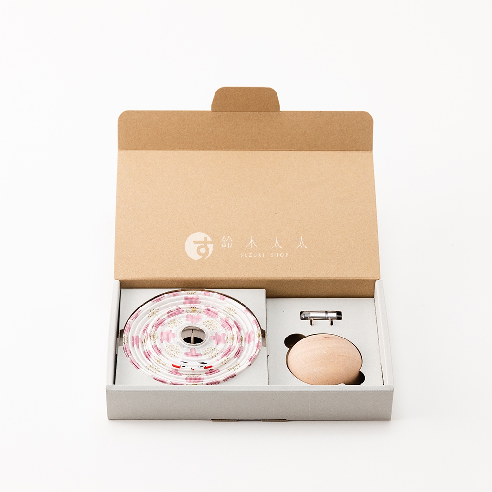 cocolan 達摩不倒翁八女迷你裝飾提燈，包含捲狀白色底布、印有粉色小花圖案的提燈燈帶，以及一個木質達摩不倒翁和金屬配件，置於紙盒內。