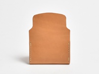 職人手作皮革迷你卡片收納夾，原色牛皮材質，簡約無綴飾設計，兩側以米白色線縫合，頂部有弧形開口，適合收納名片或悠遊卡。