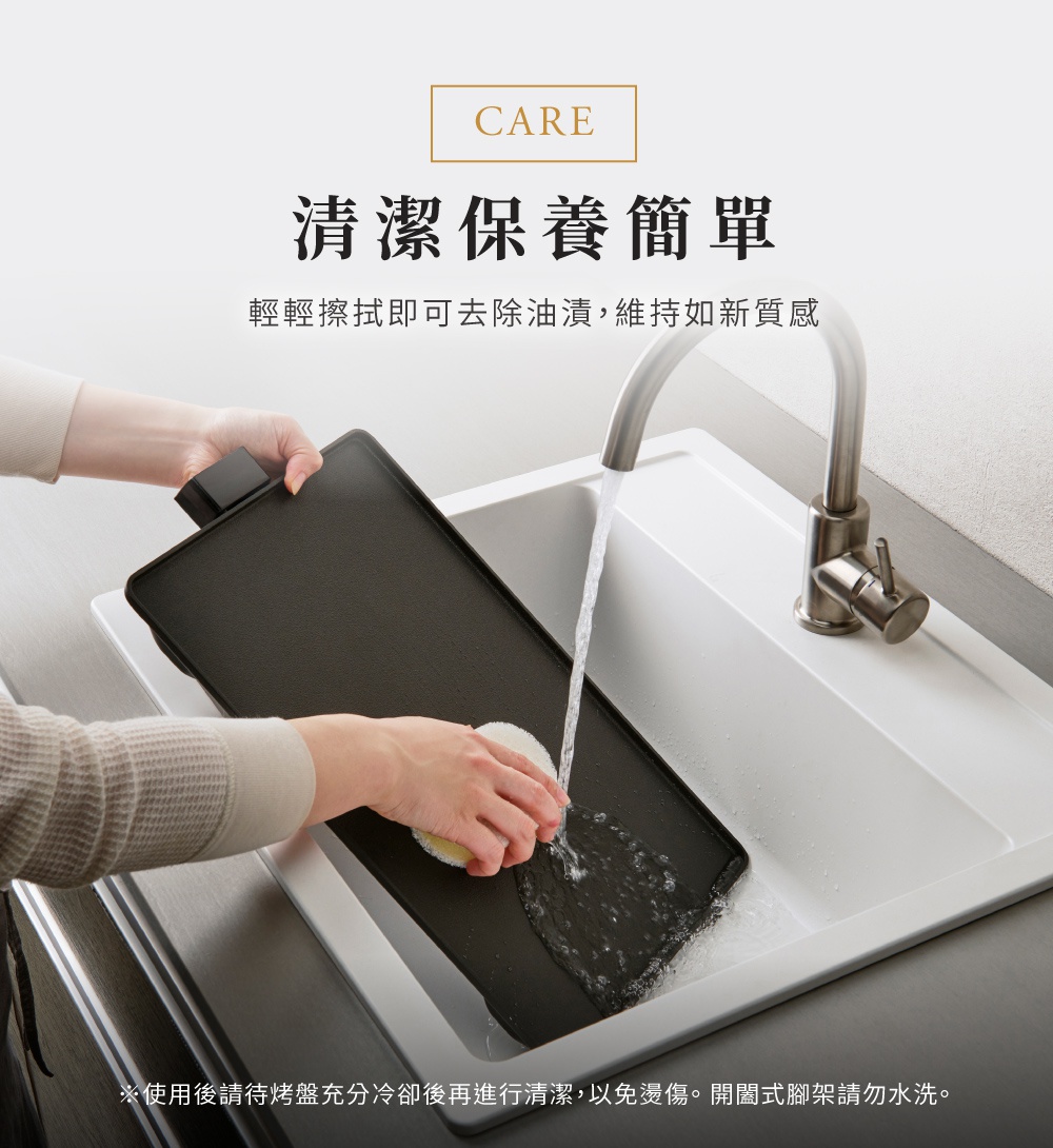 一隻手正用黃色海綿清潔黑色輕薄電烤盤，烤盤放在白色水槽中，水龍頭正流水沖洗。