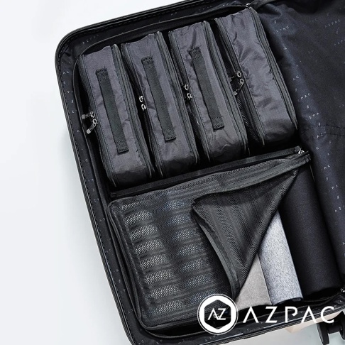 AZPAC 品牌標誌的黑色旅行收納袋組，內部裝有四個長方形收納包，下方為一個網狀收納袋，內有摺疊衣物。