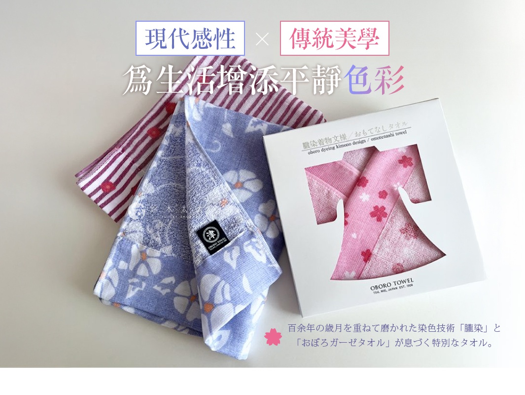 精緻的津OBORO紗布毛巾，左側展示兩款不同圖案的毛巾，一款為紅紫條紋愛心圖案，另一款為淺藍底白花圖案，右側為包裝盒，內展示粉色櫻花圖案的毛巾，盒上印有日文與英文產品資訊，下方有日文說明文字。