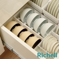 抽屜式餐碗收納架整齊擺放著白色和米色的碗，以及疊放的白色盤子
